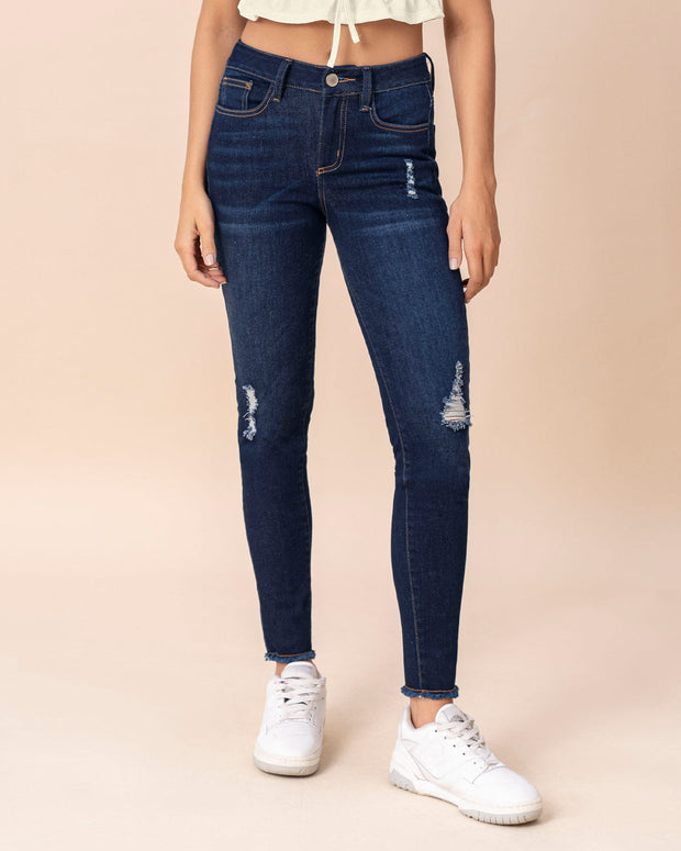 Jean skinny tiro medio con detalles desgastados