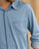 Camisa manga larga con botones funcionales y bolsillo frontal#color_557-azul-claro
